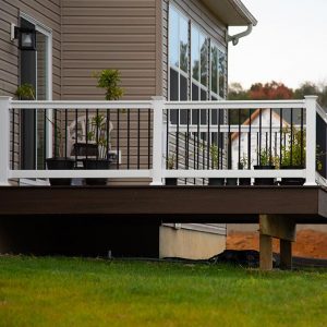 A home with a deck that has a white railing 