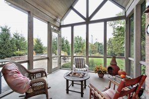 A home with a screen in porch that has outdoor furniture and a beautiful view of the backyard